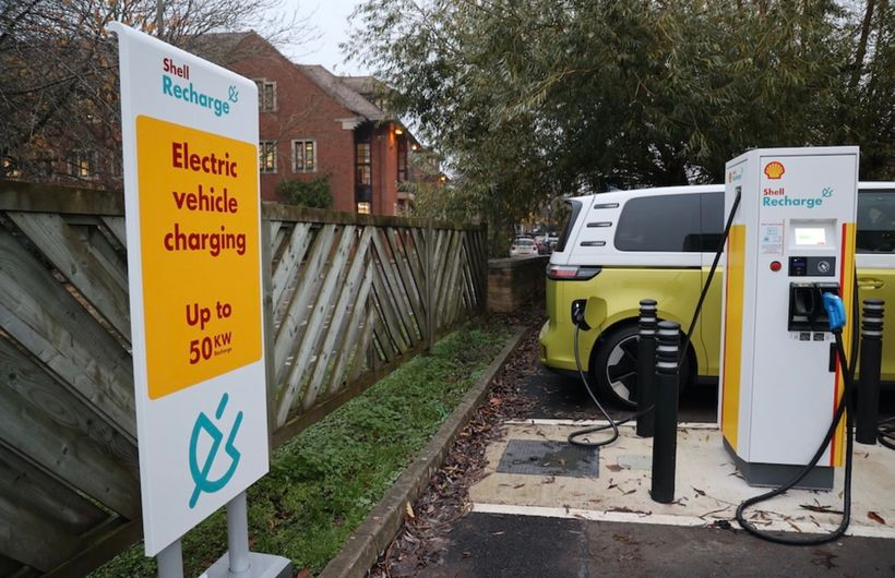 An electric Volkswagen ID.Buzz at a Shell rapid charger in a car park
